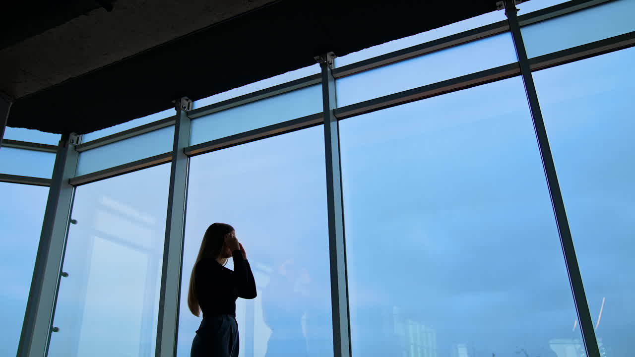 woman in eyeglasses while standing by the window