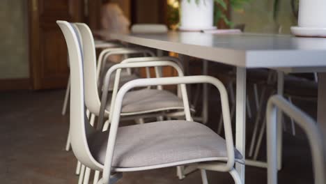 witte stoelen rond een lange tafel