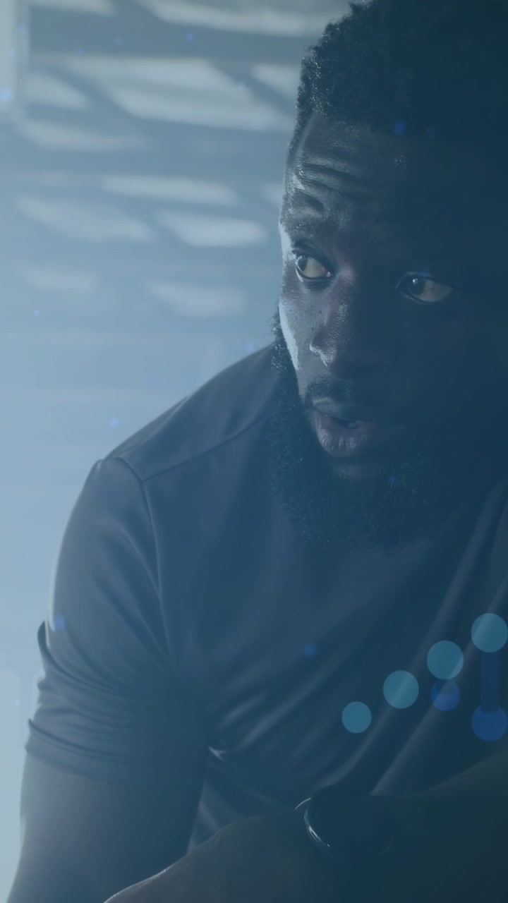 Vertical video: Man lifting arm as blue dot overlay sweeping face, shielding then peering for tech