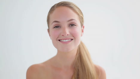 Smiling-woman-using-a-cotton-wool-on-her-face