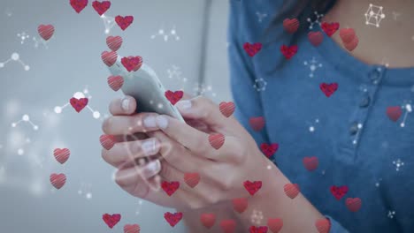 Animación-De-Iconos-De-Corazón-Sobre-Una-Mujer-Caucásica-Usando-Un-Teléfono-Inteligente