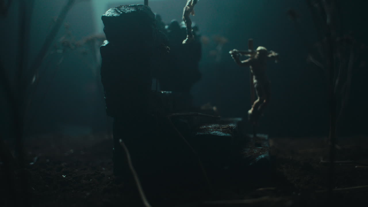 A miniature mummified doll hanging on the gallows at night