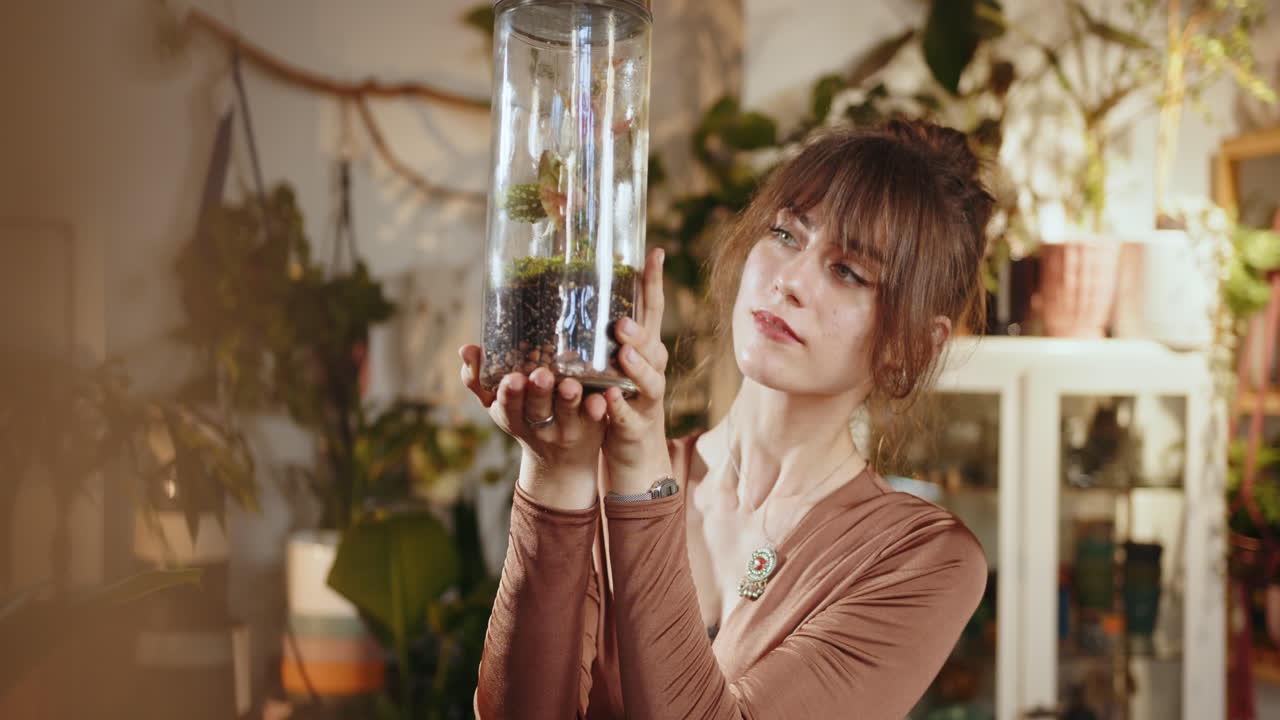 una mujer admirando un hermoso terrario.