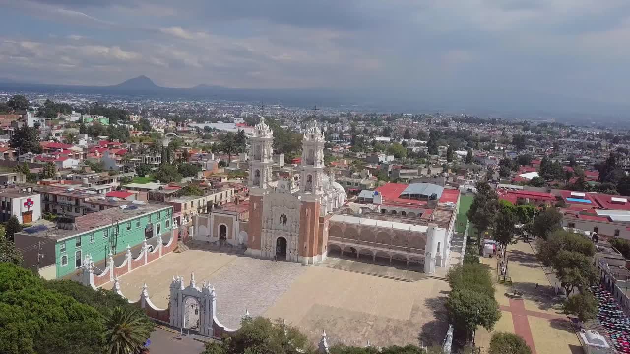 Drone orbit capturing the Basilica of Ocotlán and its iconic white towers. Shot in 4K with clear skies in Tlaxcala, Mexico