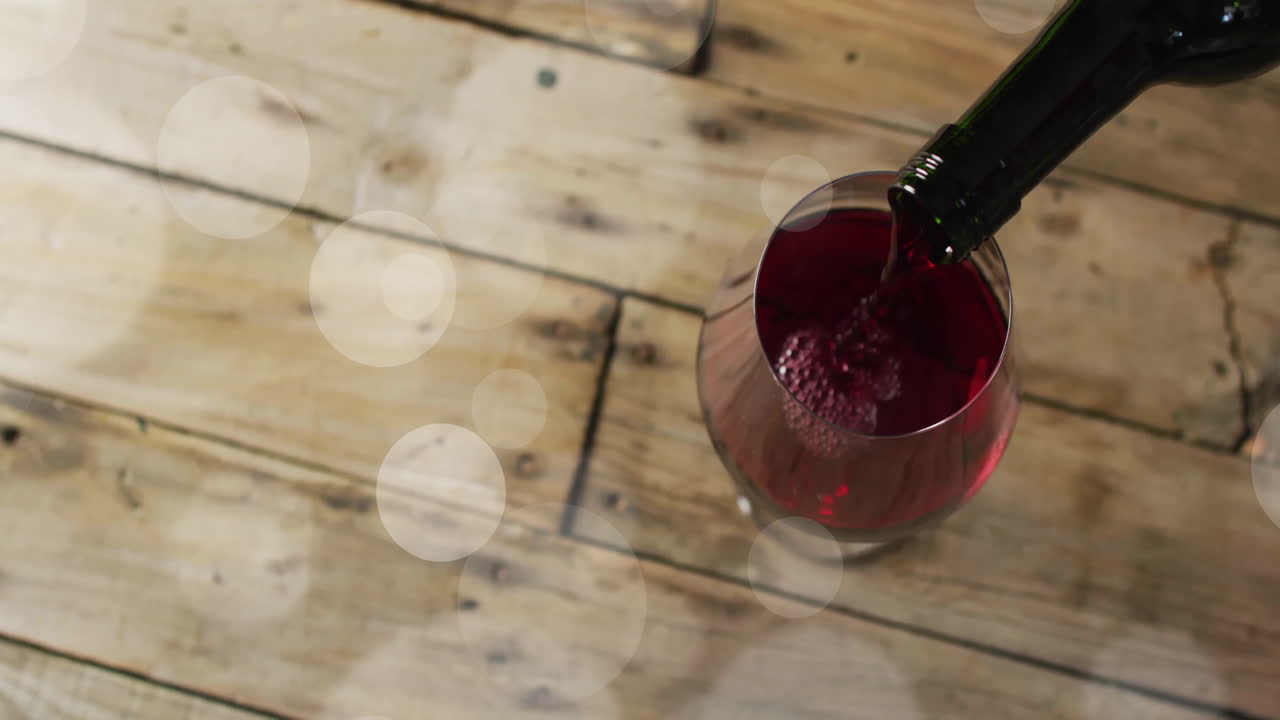 Composizione di vino rosso versato in un bicchiere su una superficie di legno