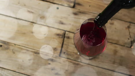 compuesto de vino tinto que se vierte en un vaso en una superficie de madera
