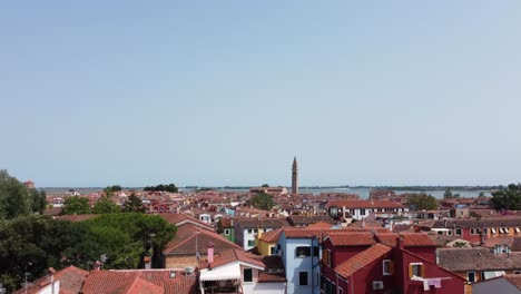 4K-Drohnenaufnahmen-Von-Burano-Venedig-Italien-Mit-Vielen-Bunten-Häusern,-Kanälen-Und-Einem-Schiefen-Turm,-Der-Im-Sommer-In-Größerer-Höhe-Fliegt