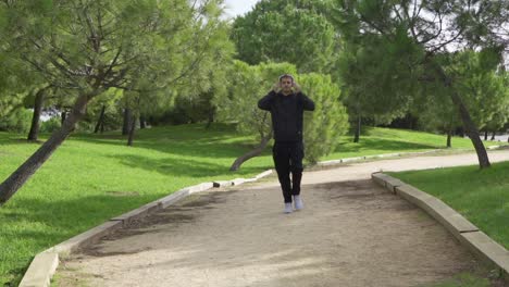 walking runner puts on white headphones and starts running