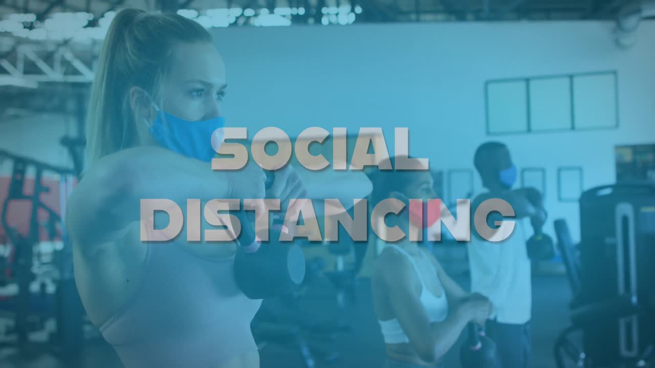 Animation of words social distancing over diverse group wearing face masks working out