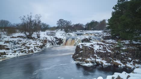 Un-Timelapse-De-Una-Cascada-De-Baja-Fuerza-En-El-Río-Tees-En-Teesdale-En-Una-Capa-De-Nieve