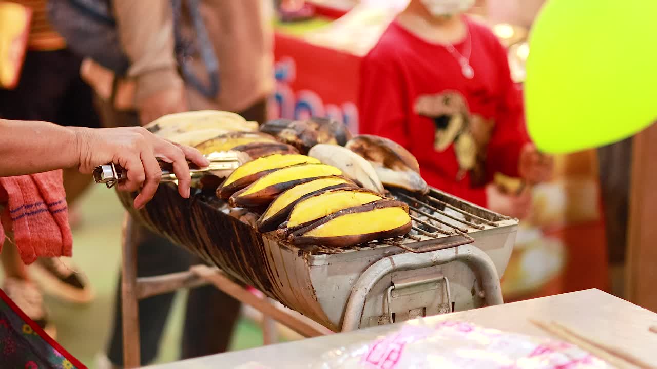 plátanos siendo asados en un mercado bullicioso