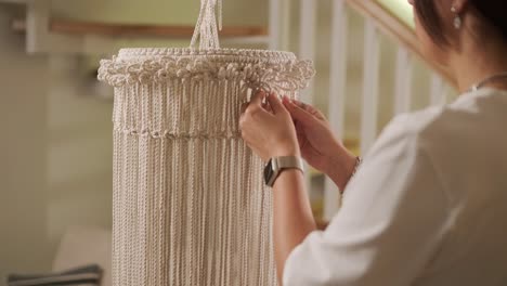 home hobby, knitting macrame. women's hands knit an ornament with thick threads.