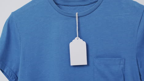 video van een blauw t-shirt met tag en kopieerruimte op een witte achtergrond