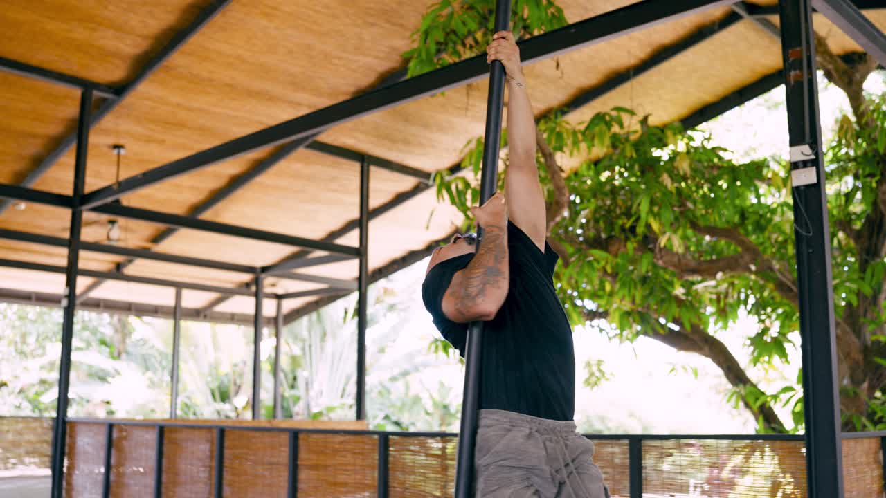 Athlete Performing Pole Climb Workout in Open-Air Studio