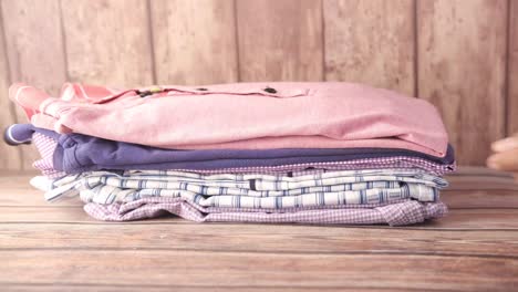 folded shirts on wooden table