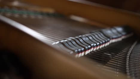 view inside a beautiful brown grand piano, hammers and strings moving as pianist plays classical music