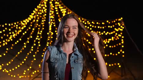 woman laughing under string lights