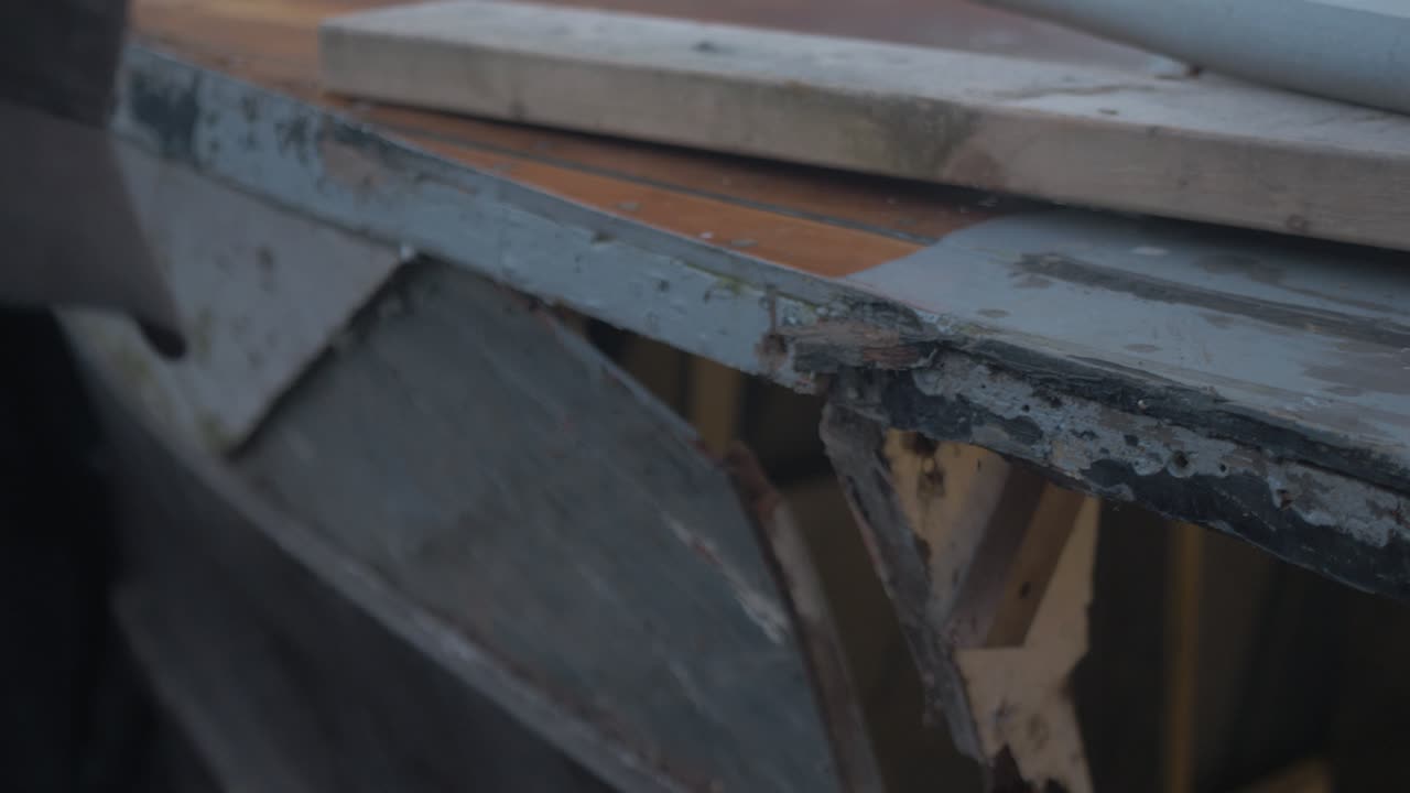 목수 는 80 년 된 수중 비행기 의 부드러운 나무 배 에서 은 어리 조각 을 제거 한다