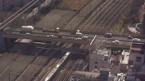 train passing under motorway in tokyo