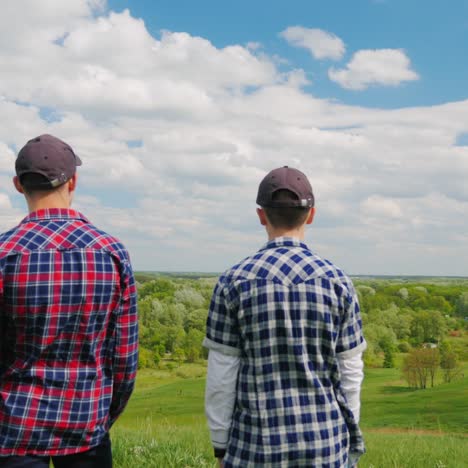 Two-Young-Men-Stand-On-Top-Of-A-Green-Mountain-1