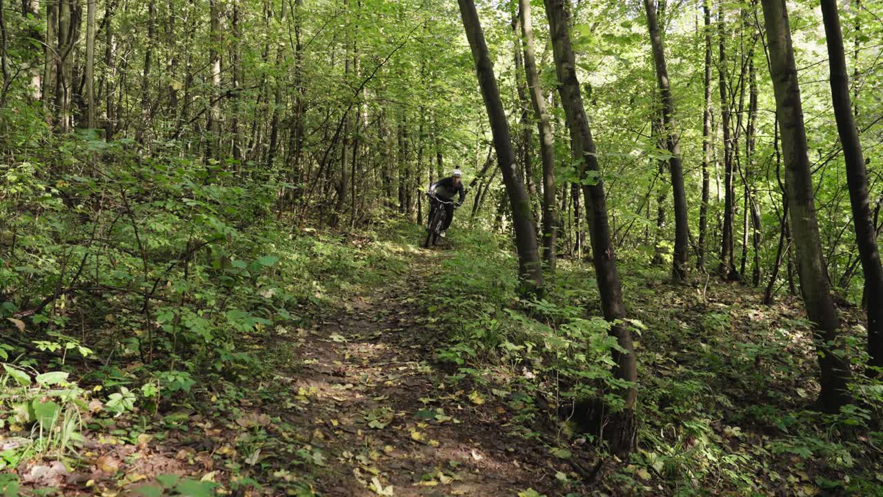 Mountain Biker Jumping Through Forest Trail
