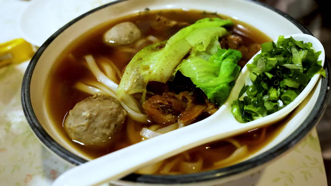 un plato de sopa de fideos de carne de res con ingredientes