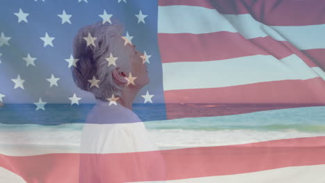 Animation-of-flag-of-usa-over-caucasian-senior-woman-on-beach-in-summer