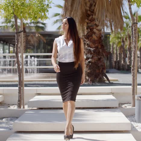 Elegant-young-woman-walking-through-a-park