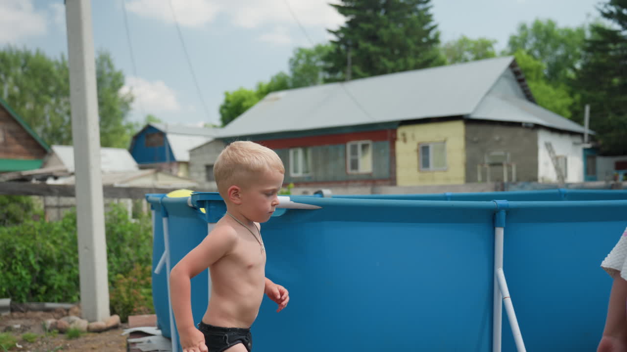 Blonde Caucasian Boy By Pool Ladder Watching Grandmother Near Wooden Shed, Summer Light, Backyard Garden, Quiet Curious Mood, Shallow Aboveground Pool, Towel On Deck, Warm Afternoon Supervision