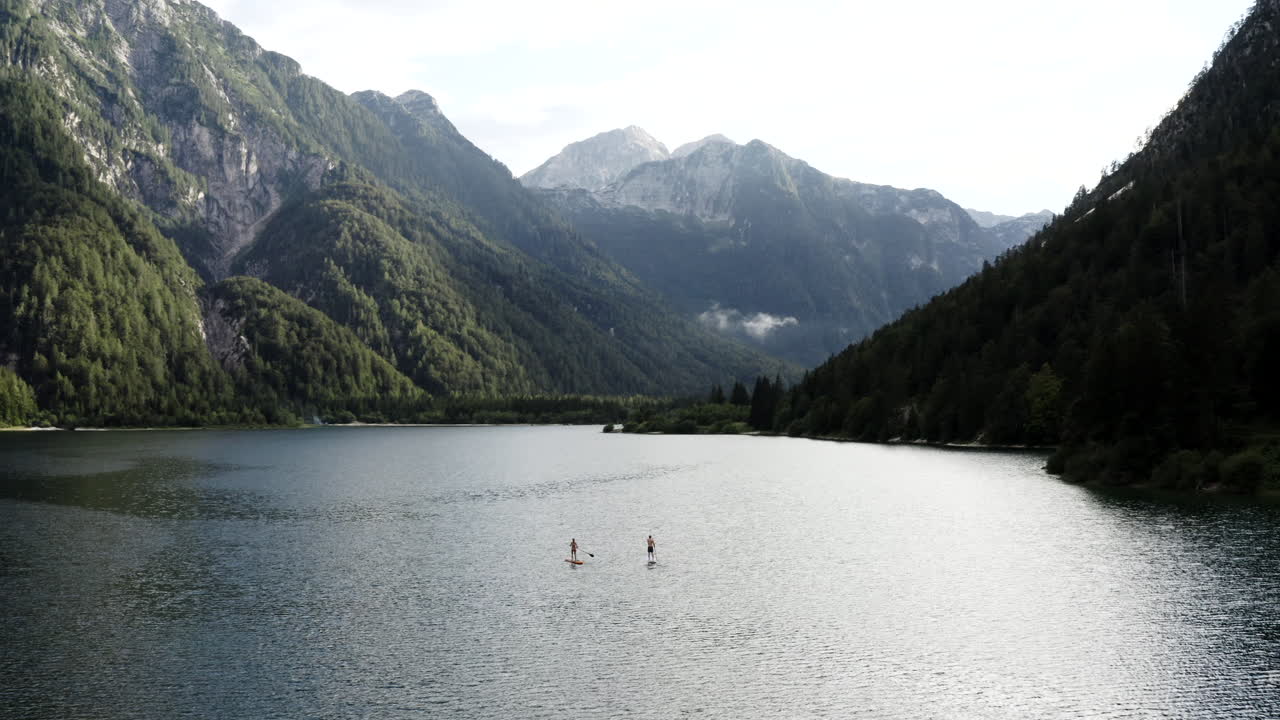 Paddleboarding on a serene alpine lake surrounded by mountains