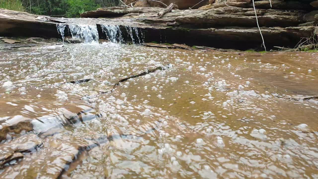 arroyo de agua de manantial de montaña corriendo por enormes losas de piedra arenisca de roca con musgo verde, algas y burbujas de agua - agua potable cristalina, meditación tranquila y pacífica naturaleza al aire libre