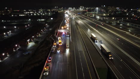 emergency vehicles with flashing lights on highway accident scene at night, aerial view