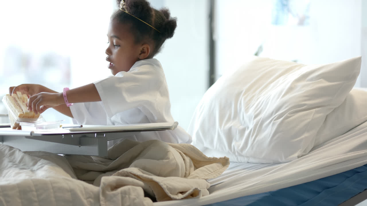 Ragazza afroamericana che pranza in un letto d'ospedale, al rallentatore