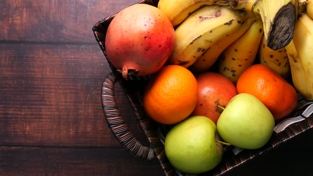 Hand picking an apple from a fruit basket