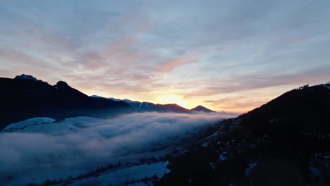 aerial view of a vivid sunset illuminating mist-covered valleys and majestic mountain peaks, creating a tranquil and breathtaking landscape. (4k)