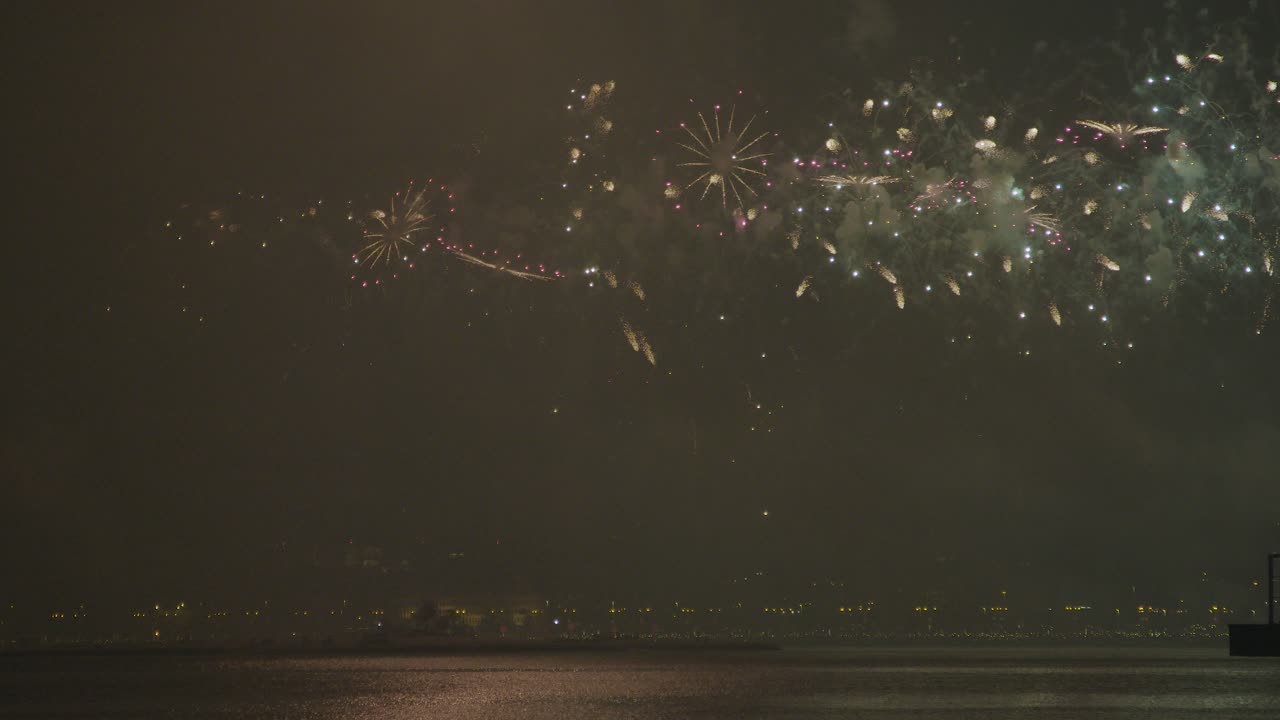 Fuochi d'artificio al rallentatore che si riflettono sulla superficie dell'acqua, illuminando il cielo in occasione del Giorno Nazionale del Qatar
