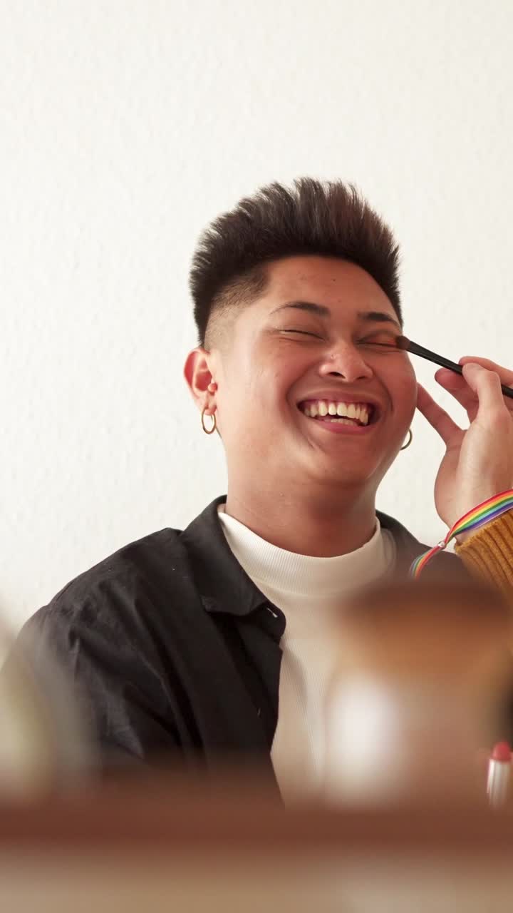 Person joyfully receiving makeup application with a brush