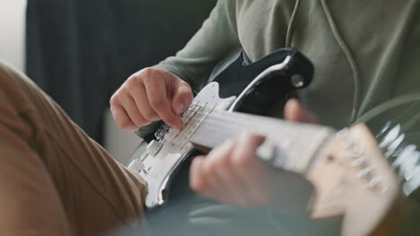 the hands of an unrecognizable man learning to play the electric guitar 1