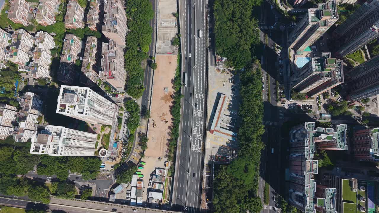Aerial view of Shenzhen shows busy elevated highways cutting through dense residential blocks and green corridors, capturing the city’s fast urban motion, infrastructure growth, China, UHD