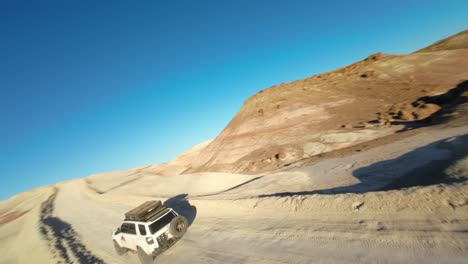 Drone-FPV-Volando-Hacia-Y-Alrededor-De-4x4-Conduciendo-Por-Un-Camino-De-Tierra-En-Utah