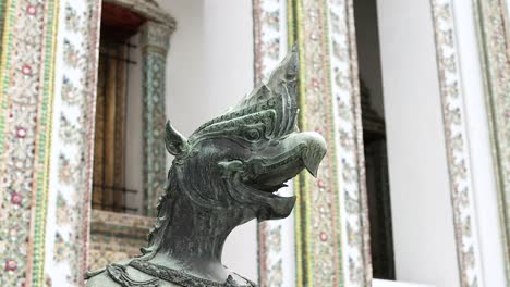 una vista detallada de una estatua mítica en wat phra kaew, bangkok, que muestra la arquitectura intrincada y el arte cultural en la iluminación natural