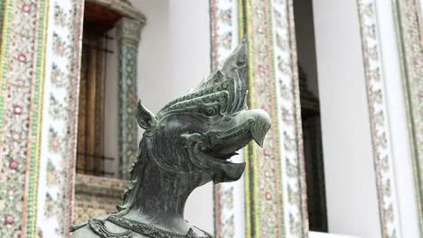 a detailed view of a mythical statue at wat phra kaew, bangkok, showcasing intricate architecture and cultural artistry in natural lighting