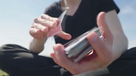 Macho-Adulto-Vestido-De-Negro-Jugando-Afuera-Con-Cartas,-Capturado-En-Cámara-Lenta