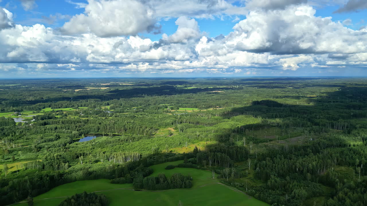 Drone footage of cumulus white clouds moving in sky over a green lands during daytime.