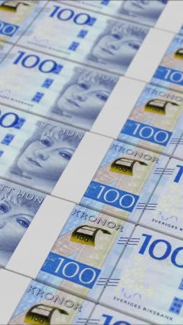 vertical video of 100 swedish krona banknotes printing by a money press