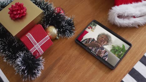 Lächelnde-Afroamerikanische-Frau,-Die-Sich-Bei-Einem-Weihnachtsvideoanruf-Auf-Dem-Tablet-Küsst