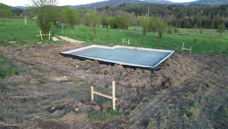 Fundación-De-Casa-Pequeña-Ubicada-En-Una-Pradera-Verde-En-Las-Montañas