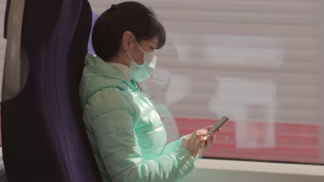 Una-Mujer-Que-Lleva-Una-Mascarilla-Médica-Protectora-Viaja-En-Un-Tren-Durante-La-Cuarentena-De-Covid-19.