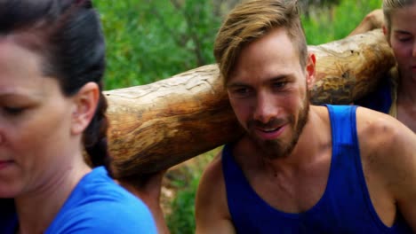 fit people carrying a heavy wooden log 4k