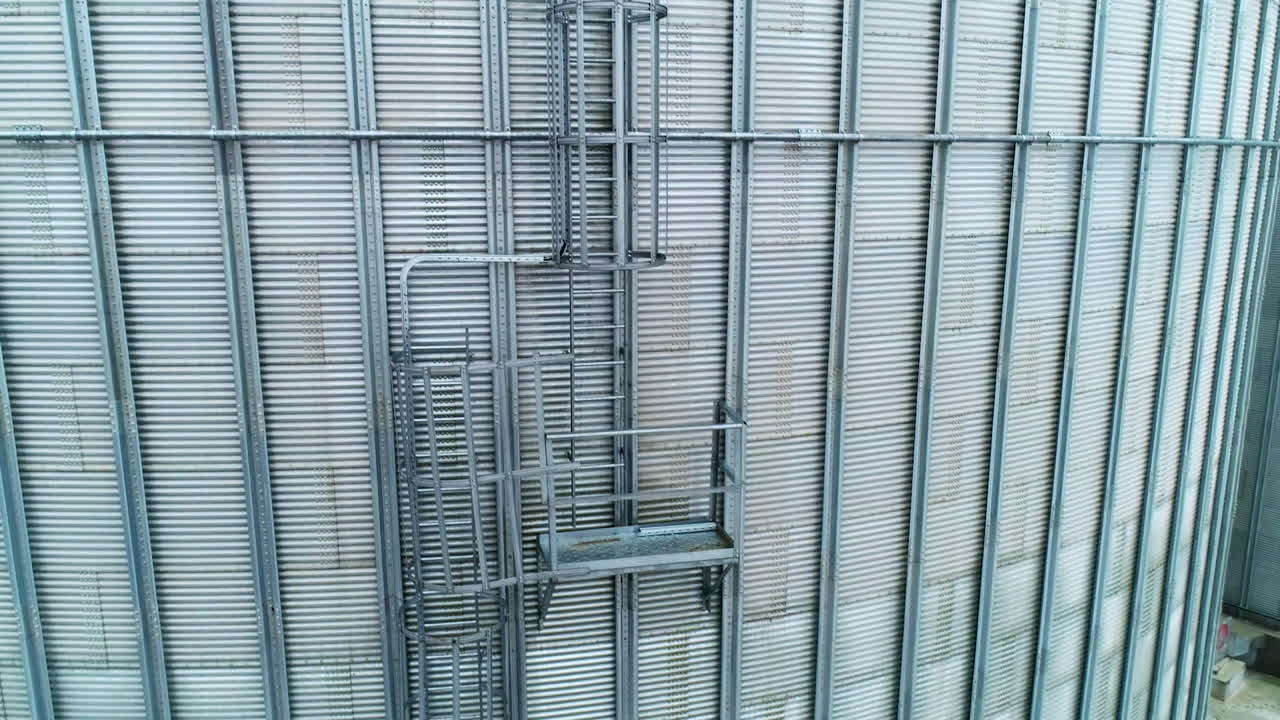 Exterior of two silo tanks in the modern agribusiness plant. Silver metal cover over the tanks for storage and processing crops.